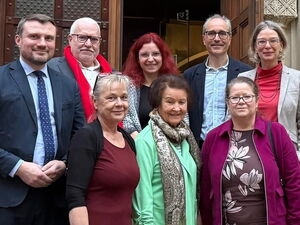Gruppenbild vor einer Eingangstür. 5 Frauen, 3 Männer in Festkleidung.